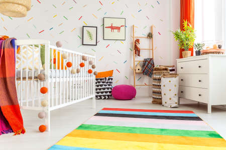 Newborn room in scandi style with white wall and rugの写真素材
