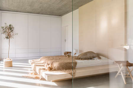 Light bedroom with king size bed and white wardrobeの写真素材