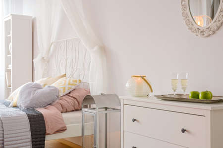 Room with bed with canopy, mirror and white dresserの写真素材