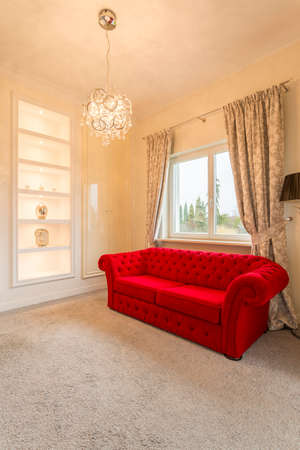 Bright room with luxurious red couchの写真素材