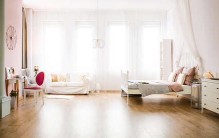 Light multifunctional room with sofa, bed, table and dresserの写真素材