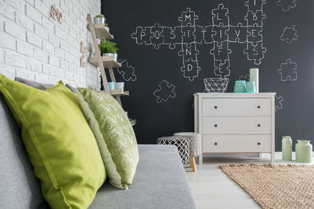 Living room with chalkboard decor, sofa, dresser and brick wallの写真素材