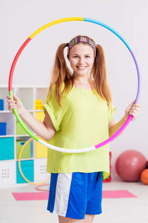 Young sportswoman holding a colorful  hoop and smilingの写真素材