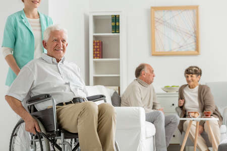 Retirement home with elder man on a wheelchair