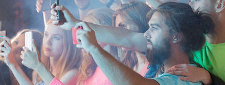 People recording the concert using their smartphones