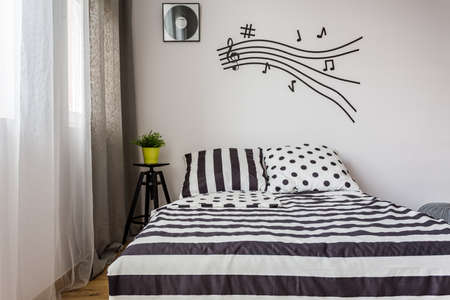 Monochrome bedroom with double bed and musical accents
