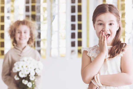 Little flirty girl and small wooer with flowers