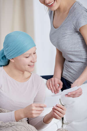 Positive cancer woman relaxing with friend at home
