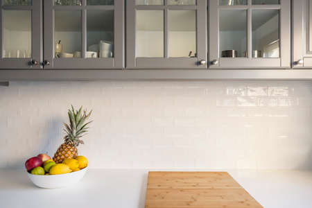 Kitchen with white worktop, grey furniture and brick tilesの写真素材