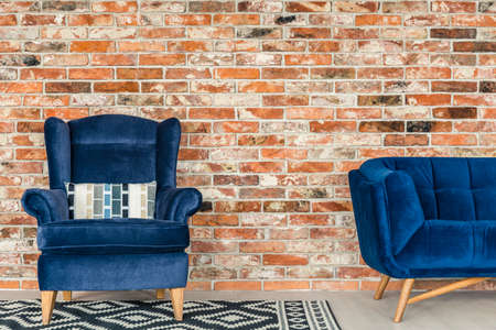 Industrial style brick wall, blue armchair, sofa and pattern rugの写真素材