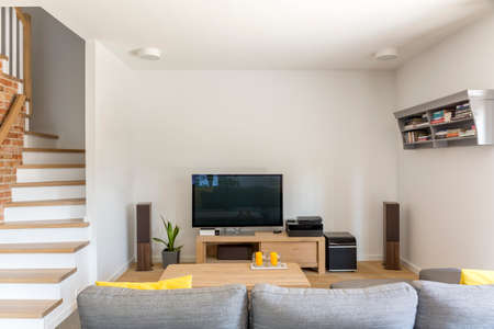 Open living room with tv, sofa and staircaseの写真素材