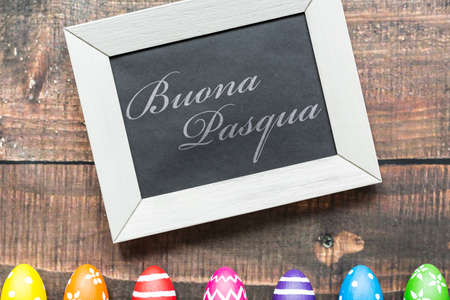 Decorative composition with easter eggs and blackboard on wood background