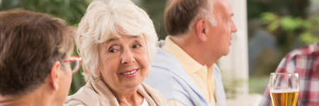 Happy elderly woman and her friends having party outdoor
