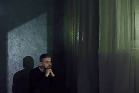 Broken mature man struggling with depression aloneの写真素材