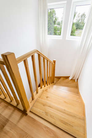 Bright house corridor with woodem stairs and window
