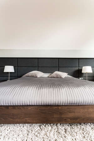 King-size bed with grey duvet and pillowsの写真素材