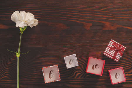White carnation and small gift boxes with love writing insideの写真素材