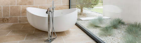 Modern designed bathtub in a bathroom with glass wallの写真素材