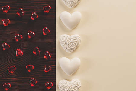 Red crystal hearts and white gyspum hearts lying on tableの写真素材
