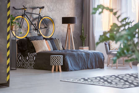 Dark hipster bedroom with window and green plantの写真素材