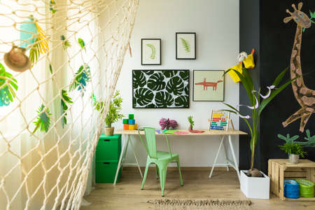 Kids study space with desk, green chair and blackboard wallの写真素材