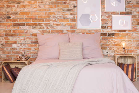 Loft bedroom with red brick wall and double bedの写真素材