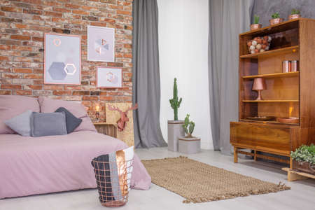 Loft bedroom with old wooden bookcase and double bedの写真素材