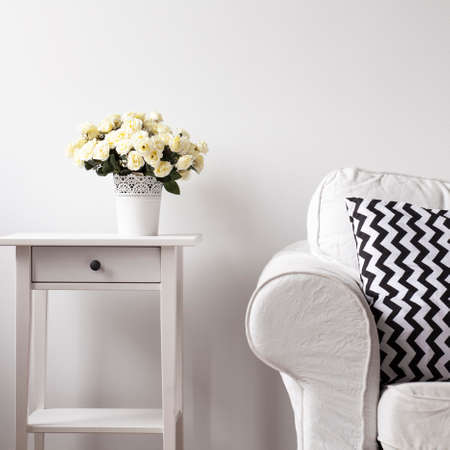 White wooden etagere and white sofa with pattern pillow on couchの写真素材