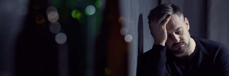 Glass bottles and sad man dealing with alcohol abuse, panoramaの写真素材