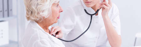 Elderly patient during the examination with a stethoscope at the doctorの写真素材