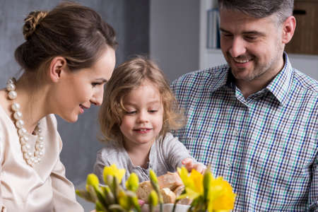 Young elegant parents with cheerful child eating family dinnerの写真素材