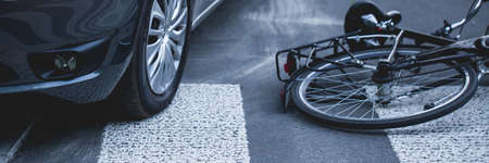 A bike lying on a street next to a car after accident, panoramaの写真素材