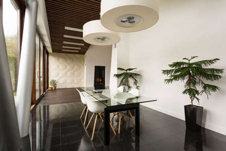 Bright villa interior with glass dining table and white chairs
