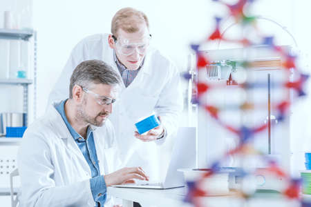 Chemists working with 3d printer and laptopの写真素材