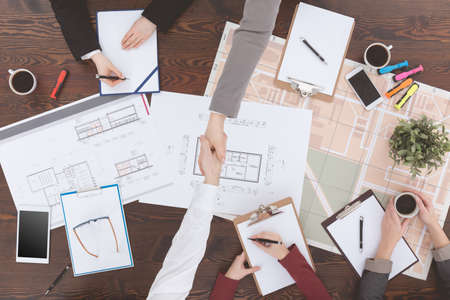 Top view of business handshake beside table after successful negotiationsの写真素材