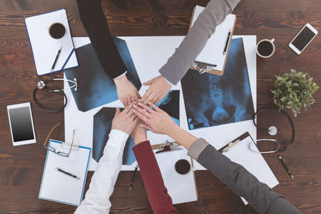 Medical team putting hands on top of each other