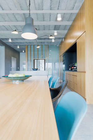 Wooden table and blue chairs in dining roomの写真素材