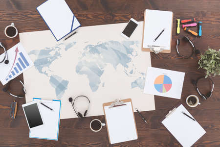 Top view of map, clipboards and headsets lying on table