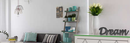 Bright panorama of a living room with white tulips in the foregroundの写真素材