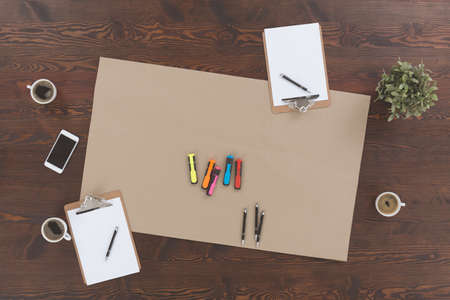 Top view of wood office desk with clipboards and coffeeの写真素材