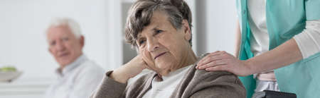 Senior worried disabled woman on a wheelchair in nursing home