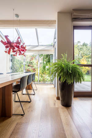 Spacious dining hall with wooden table and floor in the big house