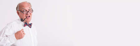 Old man is having fun with posing with fake pipeの写真素材