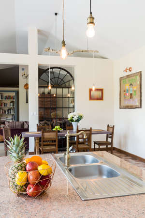 View from kitchen on countertop and dining table with chairsの写真素材