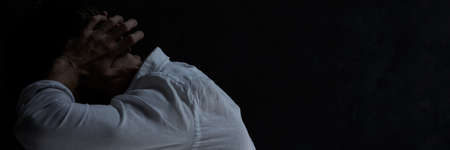 Lonely young man with schizophrenia having hearing hallucinationsの写真素材