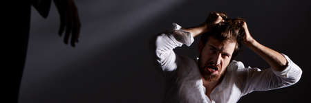 Young scared man with schizophrenia having visual hallucinationsの写真素材