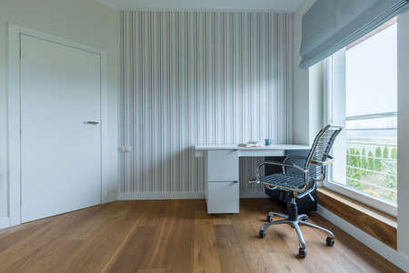 White spacious study room with wooden parquet and stripes on the wall