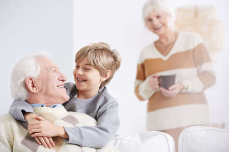 Grandmother and happy boy embracing his beloved grandfather