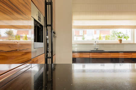 Black wheat and wooden units in modern kitchenの写真素材