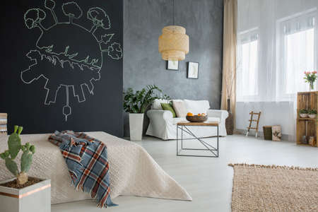 Grey apartment with bed, chalkboard, cactus, table, lamp and sofa